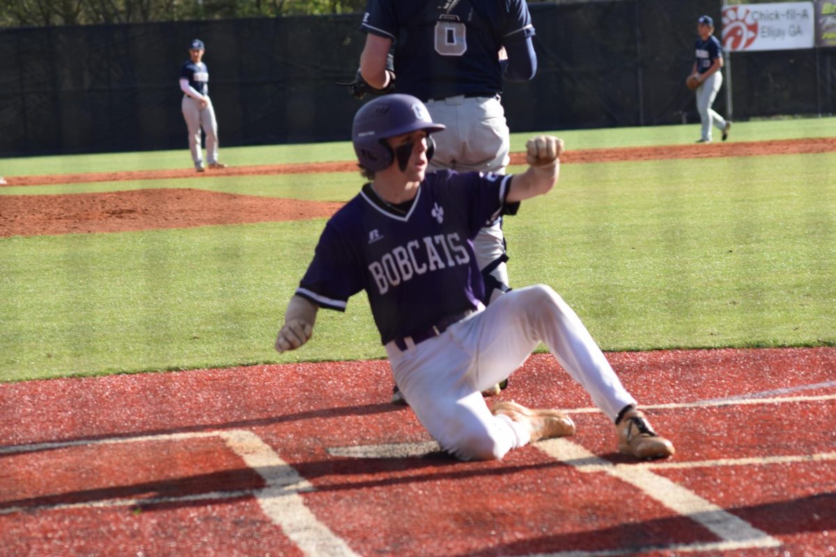 Junior Hayden Berry slides into home to score for the Bobcats.